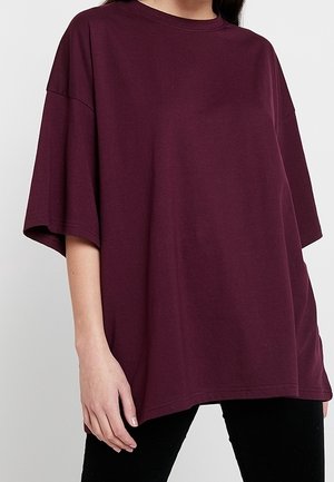 T-shirt oversize bordeaux en coton, doté d'un col rond et d'une coupe épaules tombantes, avec des manches courtes et une coupe décontractée.