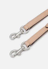 Kožený pásek v světlé béžové barvě s tmavými okraji, se dvěma stříbrnými kovovými otočnými sponami. Hladký povrch s úhledným prošitím.