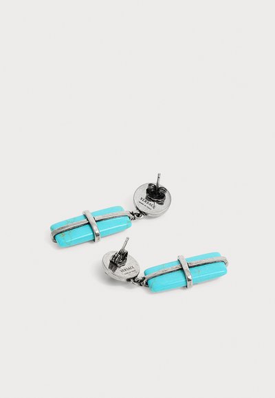Boucles d'oreilles clous en argent avec de longues pierres rectangulaires turquoise maintenues par des bandes métalliques, marquées "Versace Made in Italy" au dos.