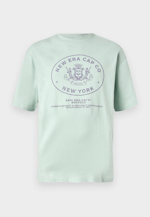 Mentazöld pamut póló rövid ujjakkal. Jellemzője egy kör alakú logó sötétlila szöveggel, amely tartalmazza a "New Era Cap Co" és a "New York" feliratot.