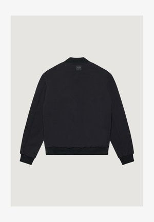 Giubbotto bomber nero a maniche lunghe con polsini e orlo a coste, visto da dietro, con una piccola patch rettangolare con logo sotto il colletto.