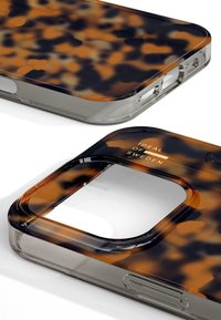 Brown and black patterned phone case with a transparent edge, an opening for the camera, and embossed “IDEAL OF SWEDEN” text.