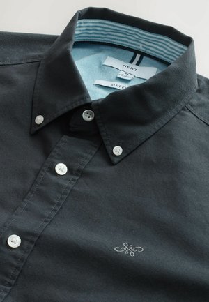 Cămașă slim-fit de culoare gri închis, cu o căptușeală a gulerului în dungi de culoare albastru deschis, nasturi albi și un mic logo brodat aproape de tiv.