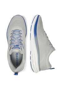 Pantofi sport gri cu un superior din plasă respirabilă, accente albastre, sireturi plate și o talpă intermediară albă cu amortizare. Dispune de o manșetă la călcâi pentru a ușura încălțarea.