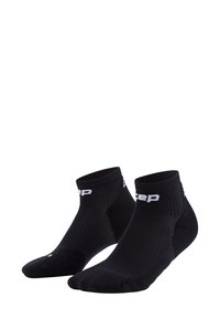 Calzini neri alla caviglia realizzati in materiale traspirante, con una texture a coste, un bordo elastico e dettagli del logo bianco sul davanti.