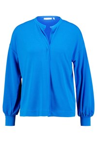 Blå tröja med rund krage, långa ballongärmar och framknäppning. Tillverkad av ett slätt tyg med en lätt glans.