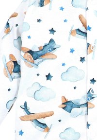 Witte stof met een speelse print van vliegtuigen in blauw en beige, met lichtblauwe wolken en sterren, en knoopdetails aan één kant.