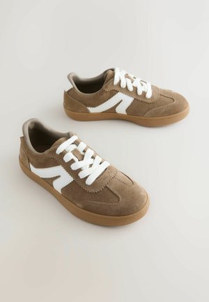 Baskets en daim marron avec des lacets blancs et un motif en zigzag blanc sur les côtés. Semelle en caoutchouc de couleur beige. Collier rembourré pour le confort.