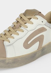 Baskets blanches et beiges avec lacets beiges, détail en daim en forme de "S", semelle texturée et marque "Replay" sur le côté et la languette.
