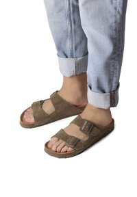 Bruna mockakängor med två justerbara remmar och metallspännen. Mönstrad innersula och gummisula. Bärs med uppvikt ljusblå jeans.