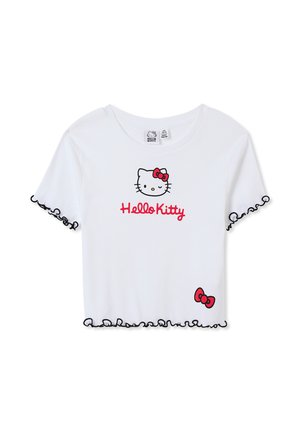 T-shirt bianco a coste con una grafica di Hello Kitty sul davanti, testo rosso e bordo nero a volant lungo le maniche e l'orlo.