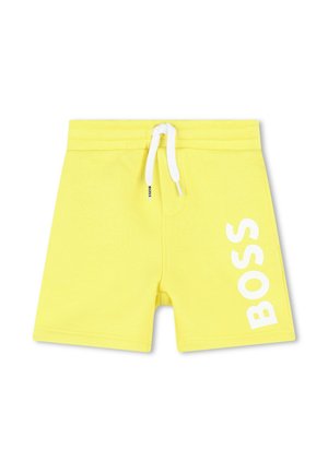Shorts de bain jaunes avec une taille élastique, un cordon de serrage blanc et un grand imprimé blanc "BOSS" sur la jambe droite. Texture lisse, design jeune.