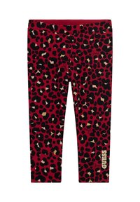 Red leggings featuring a black and gold leopard print design. "Guess" logo printed in white on the lower right leg. Smooth, stretchy material.