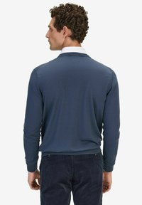 Blått stickat tröja med hög krage. Långa ärmar, ribbad nederkant och detaljer på axlarna. I kombination med mörka kordbypants.