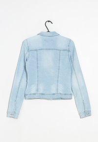 Vaaleansininen farkkutakki, jossa on pitkät hihat, nappi-rannekkeet, kauluksessa ja ommeltuja yksityiskohtia olkapäissä ja selässä.