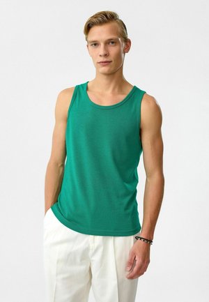 Groen mouwloos tanktop gemaakt van lichtgewicht stof, met een ronde halslijn en een relaxte pasvorm, gecombineerd met lichte broeken.