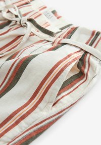 Striped, lightweight fabric shorts in cream, with vertical bands of rust, olive green, and orange. Features a tied waistband and side pockets.
