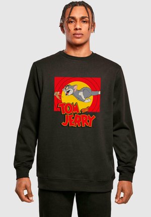 Schwarzer Pullover mit einem Grafikdesign von Tom und Jerry. Das Design zeigt einen roten Hintergrund mit einem gelben Kreis und fettgedrucktem Text darunter.