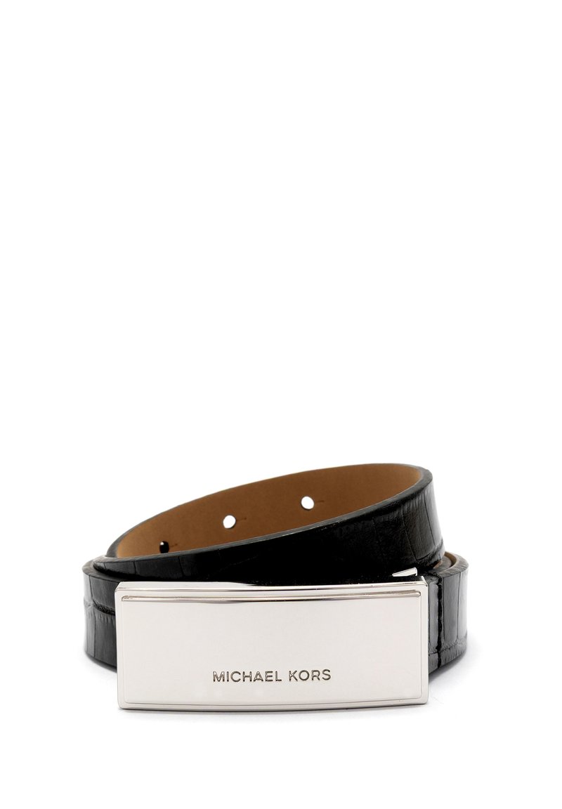 Czarny skórzany pasek z prostokątną, wypolerowaną srebrną klamrą grawerowaną logo "MICHAEL KORS", zwinięty na białym tle.