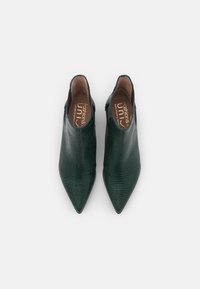 Chaussures vertes à bout pointu en matériau texturé, avec un design à encolure basse et une doublure intérieure lisse, sans matériel visible.