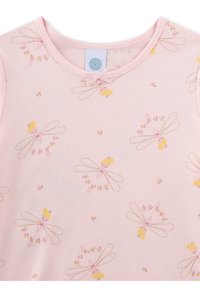 Light pink short-sleeve shirt featuring a repeated fairy print in soft yellow and pink, with floral accents and a round neckline.