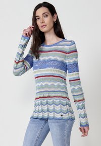 Multifarvet strikket sweater med bølgede striber i blå, grøn, rød og hvid. Lange ærmer med rund halsudskæring og struktureret design.