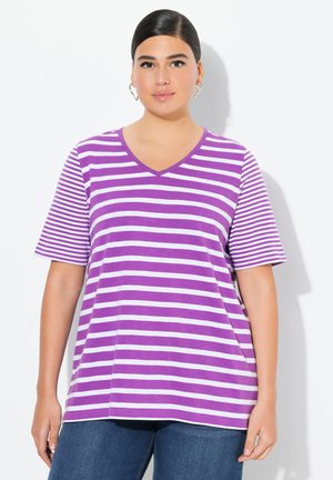 Lila und weiße gestreifte V-Ausschnitt-T-Shirt mit kurzen Ärmeln, aus weichem Stoff, lässiger Schnitt, kombiniert mit blauen Jeans.