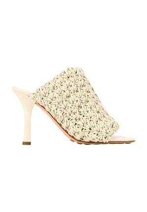 Beige mule-sandal med høje hæle, vævet og knyttet overlæg og en slank stilet-hæl på hvid baggrund.