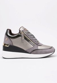 Zapatillas de mujer con suela de cuña, que presentan cuero y ante gris, detalles metálicos, un zipper lateral y una suela de goma blanca.