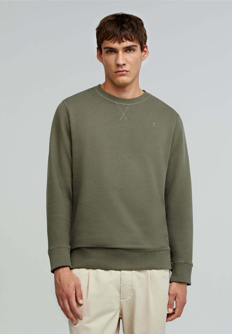 Olivgrön sweatshirt tillverkad av mjukt tyg; har en ribbad rundhals, långa ärmar och en subtil logotyp på bröstet.
