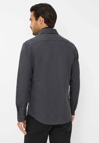 Heren overhemd met lange mouwen in donkergrijze, gestructureerde stof, met een button-down kraag en manchetten, voorzien van subtiele stikdetails.