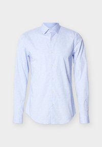 Chemise manches longues bleu clair en tissu doux, avec un motif floral subtil, fermeture boutonnée à l'avant et col classique.