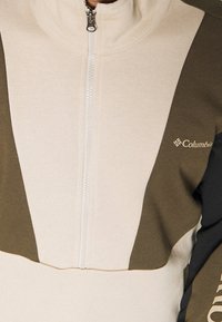 Felpa con zip Columbia con design bicolore, pannelli beige e verde oliva, tessuto texturizzato e zip frontale.