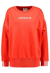 Červená bavlněná mikina s kulatým výstřihem, volným střihem, žebrovanými manžetami a bílým logem Adidas na přední straně.