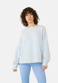 Helles blaues, übergroßes Sweatshirt mit gerippten Bündchen und Saum, kombiniert mit eng anliegenden, hellblauen, gerippten Leggings. Aus weichem Baumwollmischmaterial.