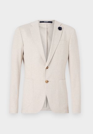 Beež bleiser klassikalise disainiga, nurgeliste klappidega, kahe esiosa tasku ja tumesinise kangast lillede aktsendiga klapperi peal.