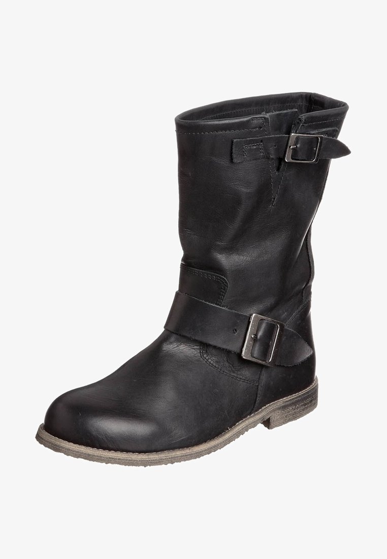 Bottine en cuir noir avec un bout rond, détail de boucle sur le côté et un talon bas. La surface texturée présente une finition légèrement vieilli.