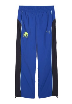 Blauwe sportbroek met zwarte zijpanelen, elastische tailleband en lichtblauwe piping. Bevat het Marseille-logo en Puma-branding.