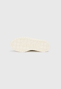 Suela de zapato de goma blanca con patrón de agarre texturizado, presentando el logotipo "HUGO" prominentemente en relieve. Diseño limpio y minimalista sin detalles adicionales.