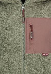 Fleecejacke in Hellgrün mit einer rosa Brusttasche. Verfügt über einen Frontreißverschluss und eine Kapuze mit Kordelzug. Weiche Textur und kontrastierende Materialien.