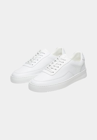 Paar weiße flache Sneaker mit Schnürung vorne, glatter Lederstruktur und flachen Gummisohlen auf schlichtem Hintergrund.