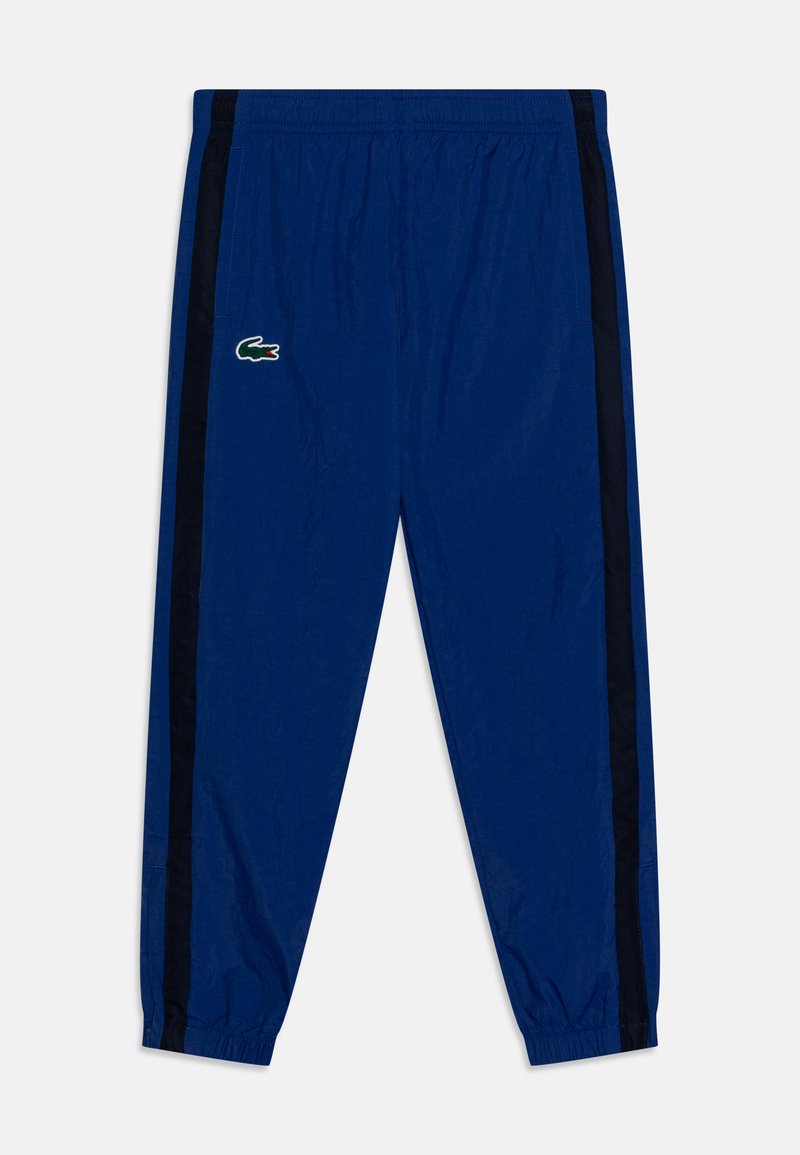 Pantalons de sport bleus en matériau léger, avec une taille élastique, des panneaux en maille sur les côtés et un petit logo brodé à l'avant.