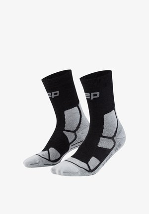 Paar schwarze und graue Crew-Socken mit gepolsterten Bereichen und einem teilweise grauen Logo nahe der Oberseite, entwickelt für sportliche Nutzung.