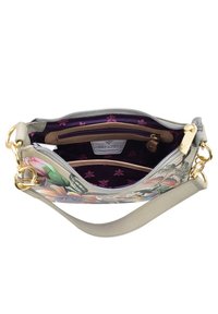 Bloemmotief handtas met een lichtgrijze buitenkant, gouden hardware en een paarse binnenkant met een ritsvak en meerdere vakken.