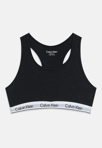 Sutien desportivo preto da Calvin Klein para idades entre os 10 e os 12 anos, com design de costas cruzadas e faixa elástica branca com o logótipo da Calvin Klein repetido.