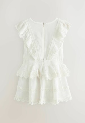 White cotton dress with ruffled sleeves, tiered design, and lace trim. Back zipper closure. Textured fabric with a lightweight feel.