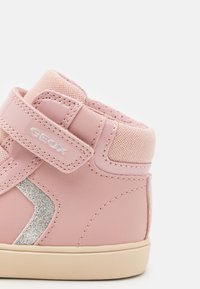 Rosa High-Top-Sneaker mit glänzender Lederoberfläche, Netzakzenten, einem Klettverschluss und einem glitzernden silbernen Designdetail. Leichte Gummisohle.