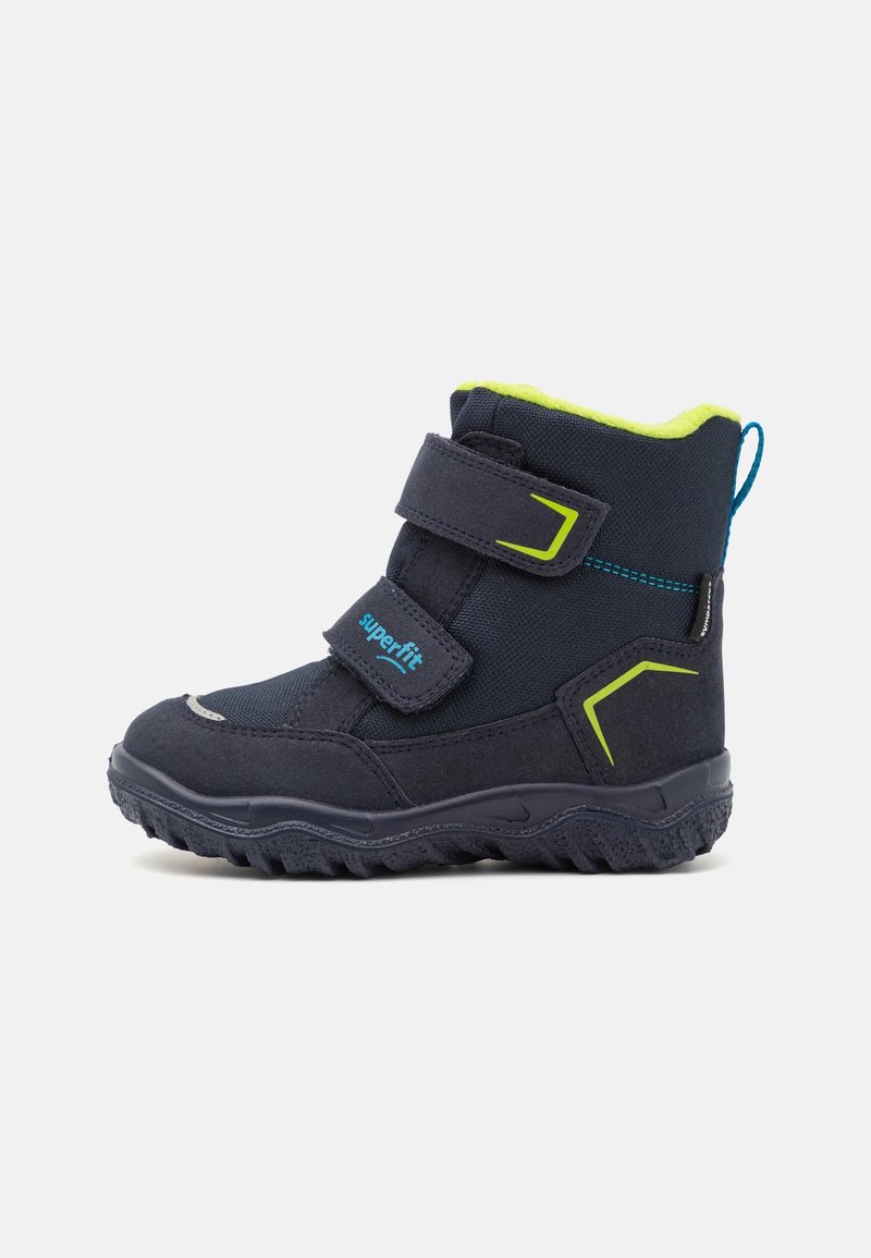 Botte d'hiver noire pour enfant avec deux bandes velcro, doublure vert citron vert et semelle robuste sur fond blanc.