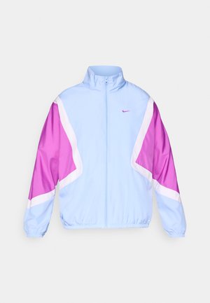 Light blue jacket with pink and white geometric patterns, high collar, full zip, and elastic cuffs. Nike logo on the chest.