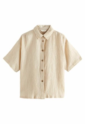 Chemise beige à manches courtes avec texture froissée, col et six boutons marron sur le devant.